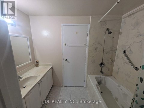 A bathroom with a white door and a shower with a glass door.