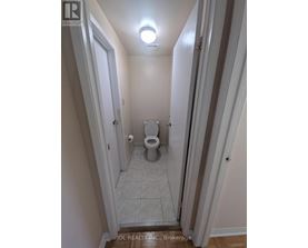 A small bathroom with a toilet and a light on the ceiling.