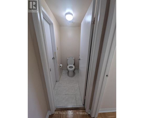 A small bathroom with a toilet and a light on the ceiling.