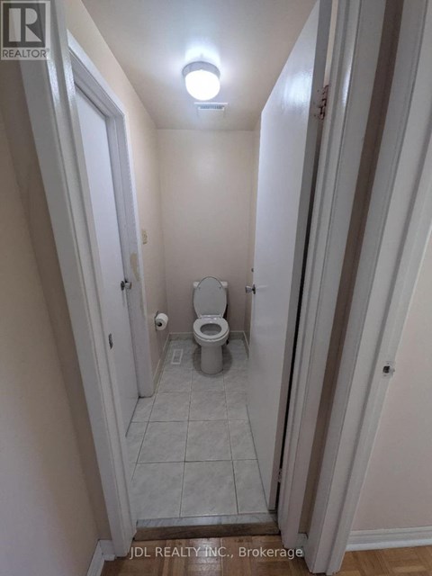 A small bathroom with a toilet and a light on the ceiling.