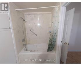A small bathroom with a bathtub and a shower.