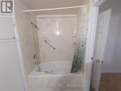 A small bathroom with a bathtub and a shower.