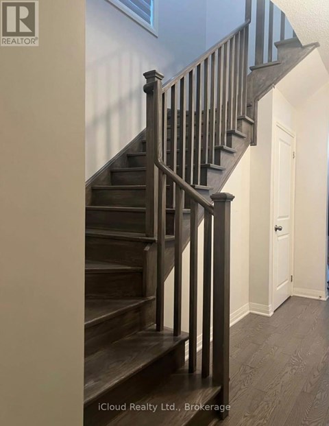 A wooden staircase with a metal railing.