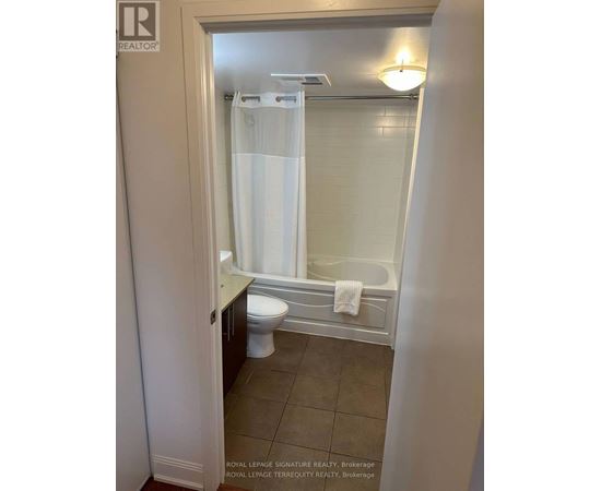 A white bathroom with a toilet and a shower stall.