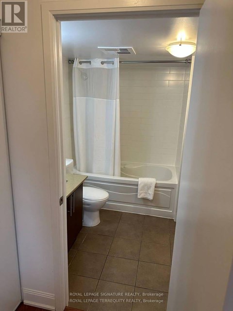 A white bathroom with a toilet and a shower stall.