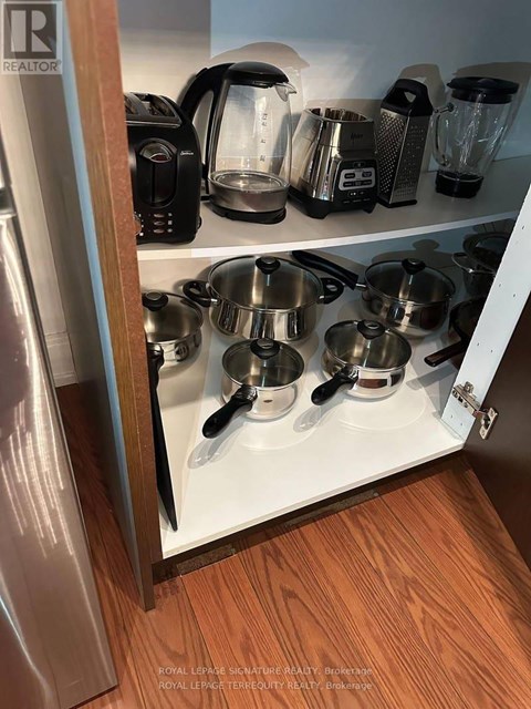 A kitchen cabinet with pots and pans on it.