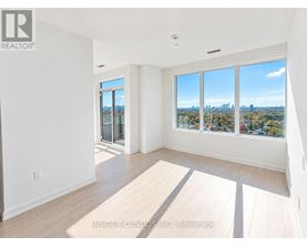 A spacious room with a view of the city skyline through the windows.