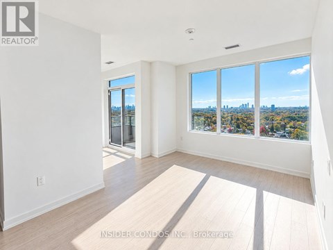 A spacious room with a view of the city skyline through the windows.