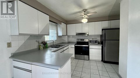 A modern kitchen with white cabinets and stainless steel appliances.