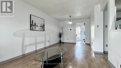 A living room with a glass table and a framed picture on the wall.
