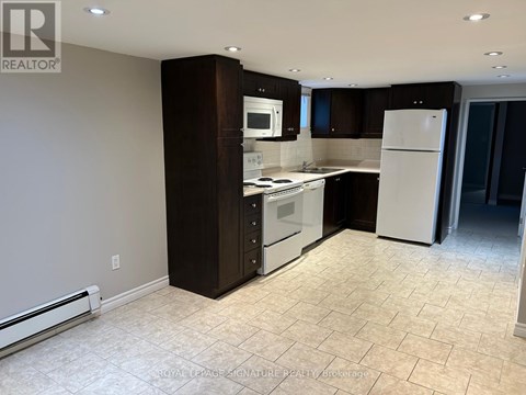 A kitchen with a white refrigerator and white tiled flooring.