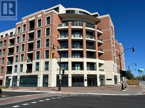 A large apartment building with a curved top floor and balconies on the upper floors.
