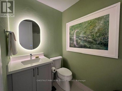 A bathroom with a green wall and a white sink.