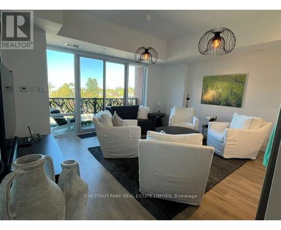 A living room with white furniture and a large window.
