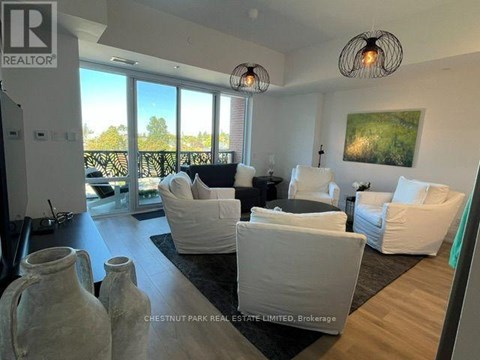 A living room with white furniture and a large window.