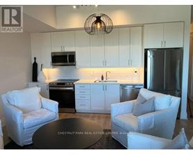 A modern kitchen with white cabinets and a black countertop.
