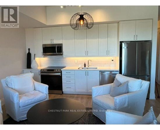 A modern kitchen with white cabinets and a black countertop.