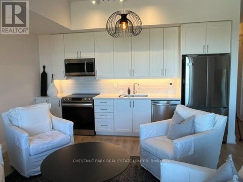 A modern kitchen with white cabinets and a black countertop.