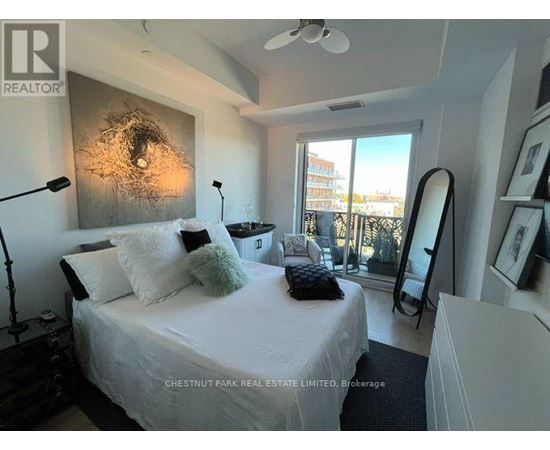 A bedroom with a bed, a mirror, and a ceiling fan.