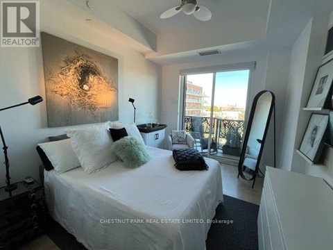 A bedroom with a bed, a mirror, and a ceiling fan.