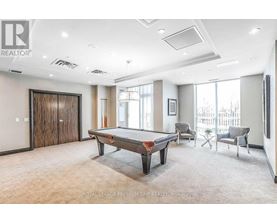 A room with a pool table and chairs.