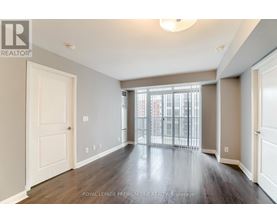 A spacious room with wooden floors and white walls.