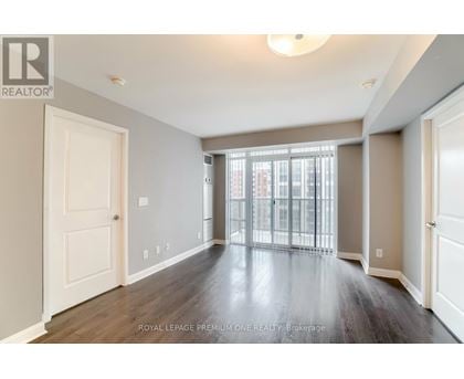 A spacious room with wooden floors and white walls.