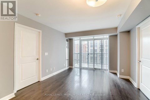 A spacious room with wooden floors and white walls.