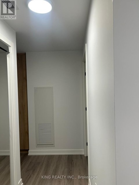 A hallway with a door and a light on the ceiling.
