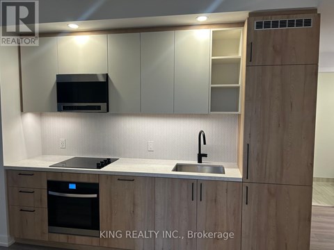 A kitchen with wooden cabinets and a stainless steel sink.