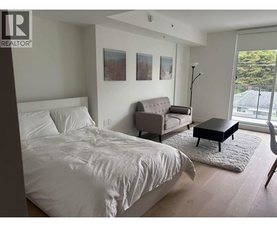 A bedroom with a bed, couch, and chair.