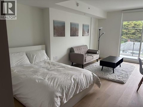 A bedroom with a bed, couch, and chair.