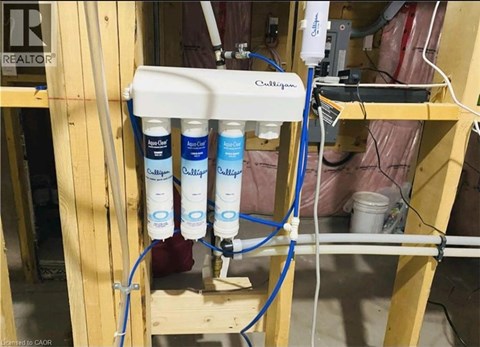 A water filtration system with four filters is installed in a room under construction.