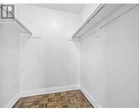 A white room with a wood floor and a white wall.