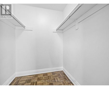 A white room with a wood floor and a white wall.