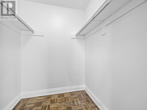 A white room with a wood floor and a white wall.