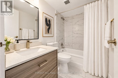 A bathroom with a sink, toilet, and bathtub.
