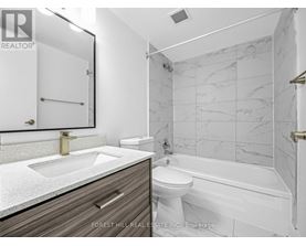 A bathroom with a marble tile wall and a white toilet.