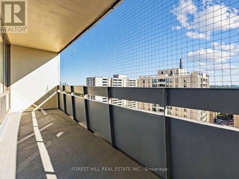 A balcony with a view of a cityscape and a building with a chimney.