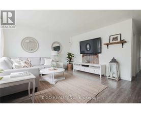 A living room with a white couch, a white coffee table, a white TV stand, and a white rug.