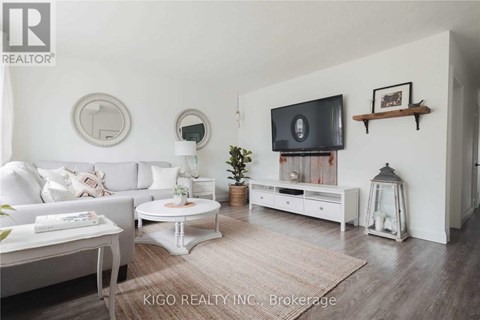 A living room with a white couch, a white coffee table, a white TV stand, and a white rug.