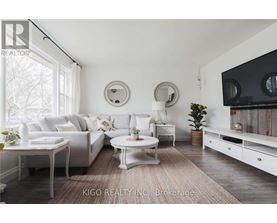 A living room with white furniture and a large window.