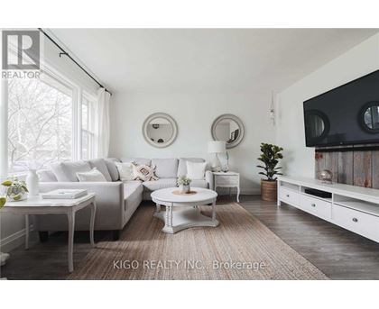 A living room with white furniture and a large window.