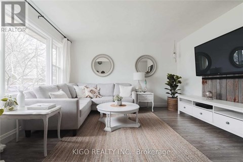 A living room with white furniture and a large window.