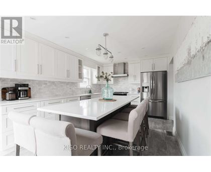 A modern kitchen with white cabinets and a central island.