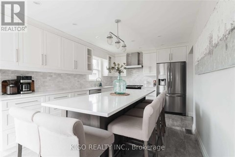 A modern kitchen with white cabinets and a central island.