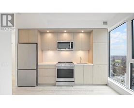 A modern kitchen with a refrigerator, oven, and microwave.