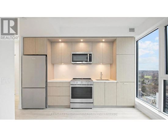 A modern kitchen with a refrigerator, oven, and microwave.
