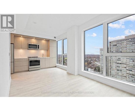 A spacious living room with a television and a large window overlooking a cityscape.