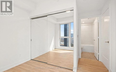 A room with a sliding glass door leading to a balcony.